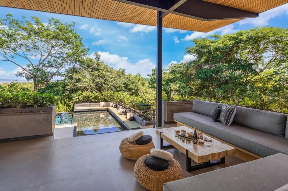 Modern eingerichtete Terrasse mit Swimmingpool in Architektur aus Holz und Glas im tropischen Regenwald