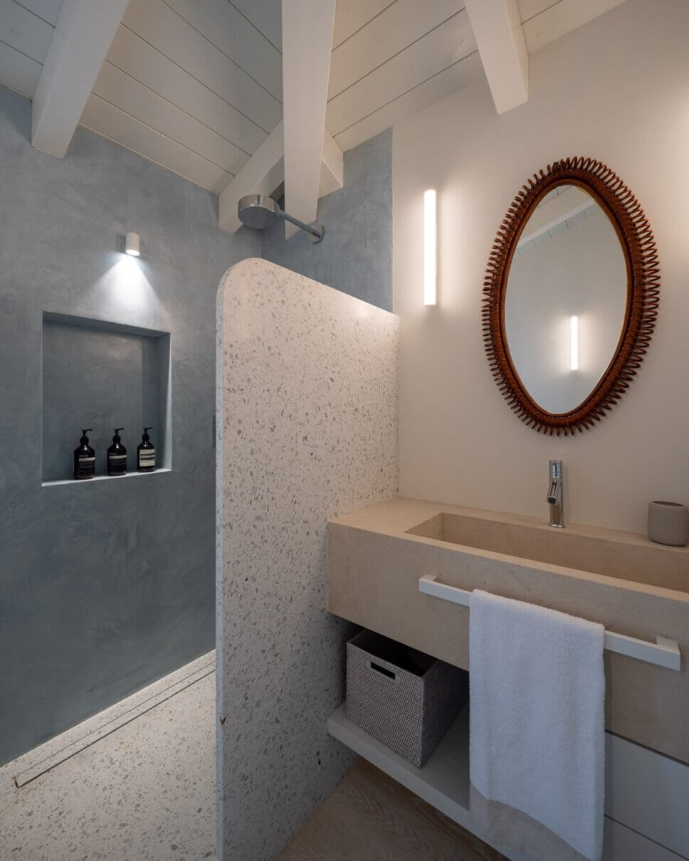 Badezimmer mit bodenebener Dusche mit Spritzschutz aus Terrazzo