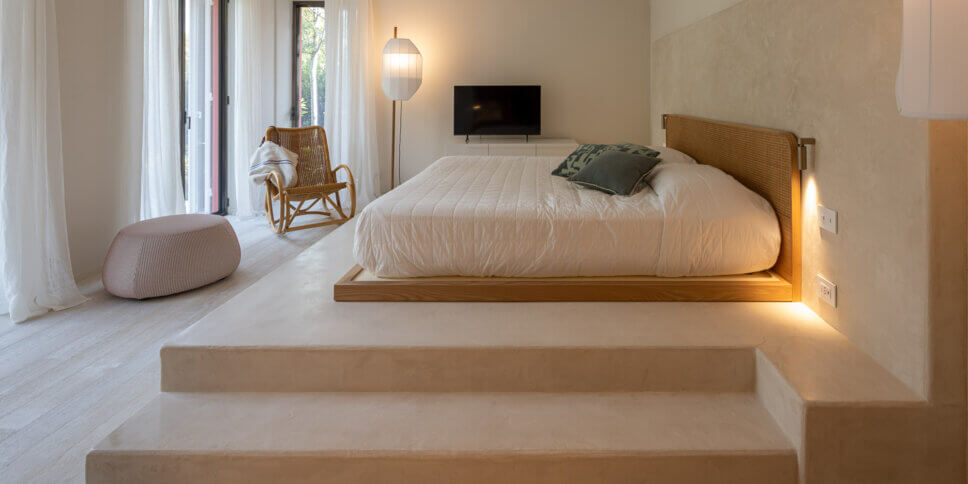 Modern eingerichtetes Schlafzimmer mit Blick auf Terrasse und Garten