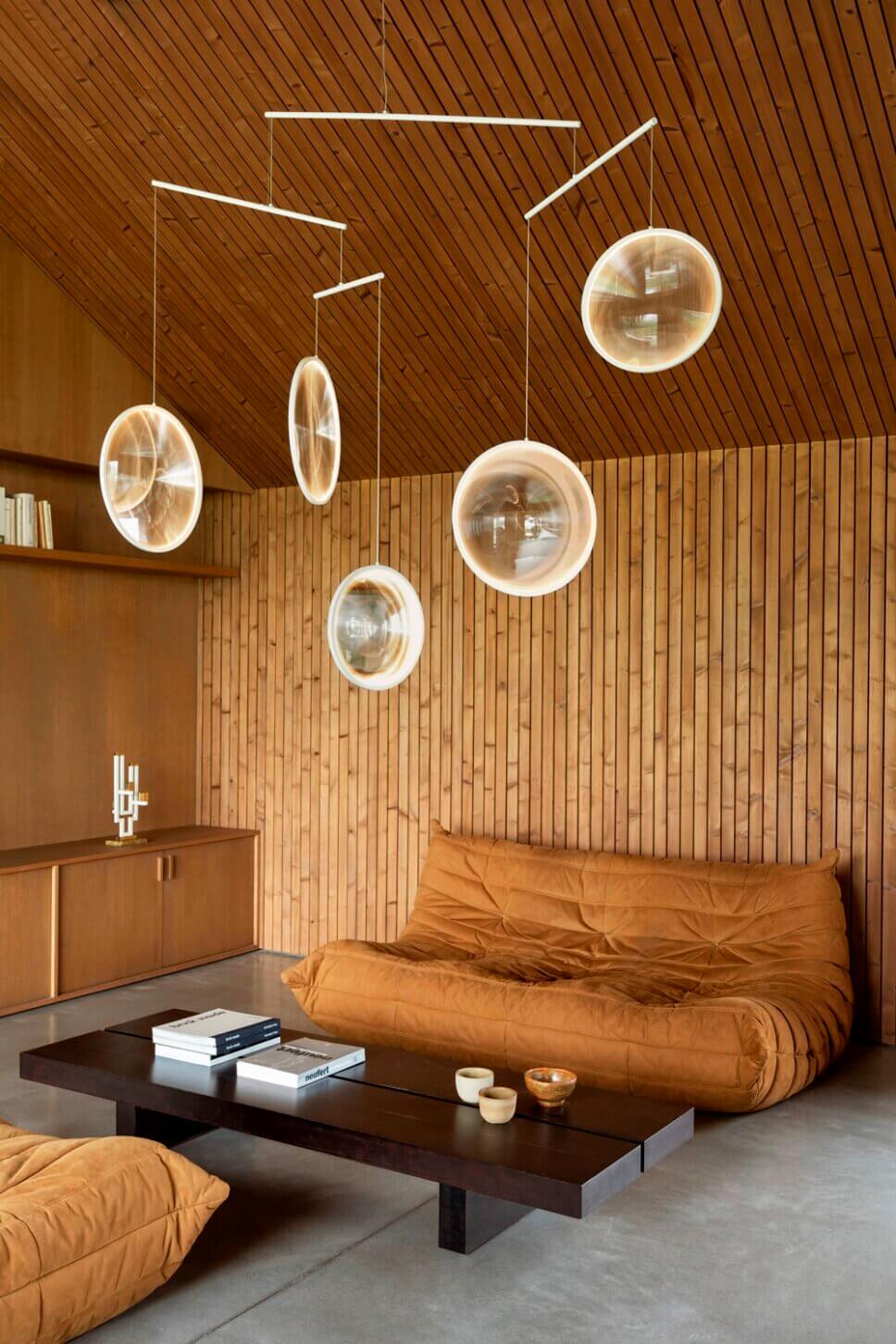 Mit moderner Designerlampe beleuchtetes Wohnzimmer