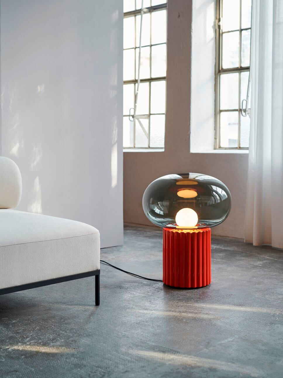 Mit moderner Designerlampe beleuchtetes Wohnzimmer
