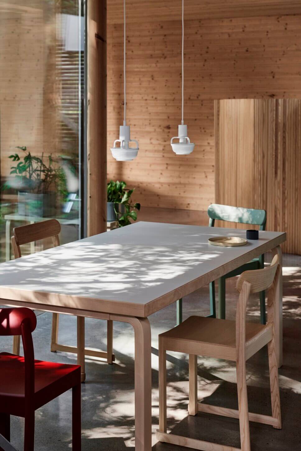 Mit moderner Designerlampe beleuchteter Esstisch