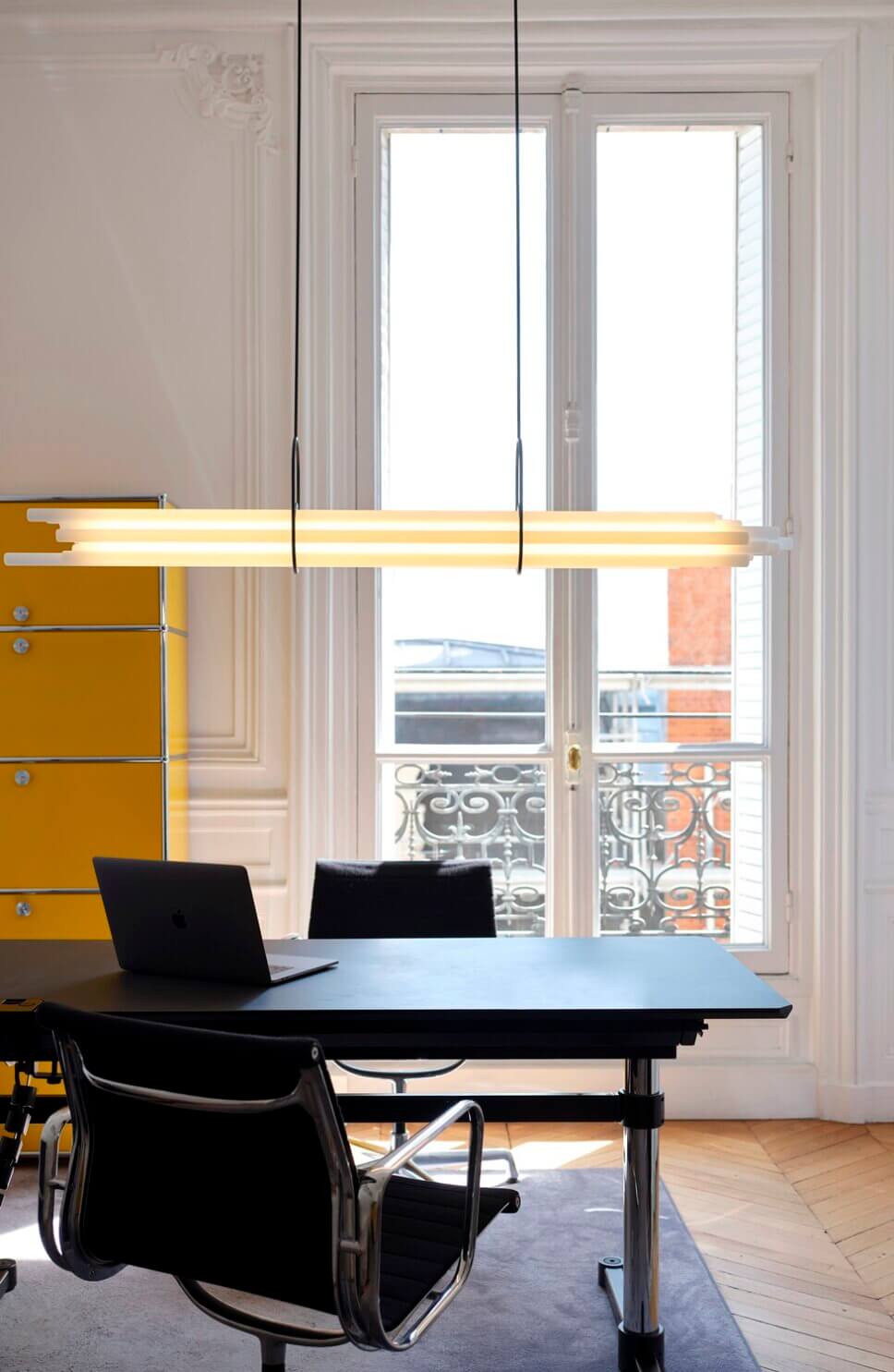 Mit moderner Designerlampe beleuchteter Schreibtisch