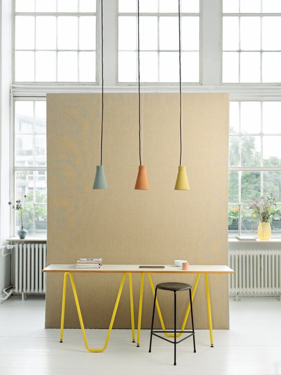 Mit moderner Designerlampe beleuchteter Schreibtisch