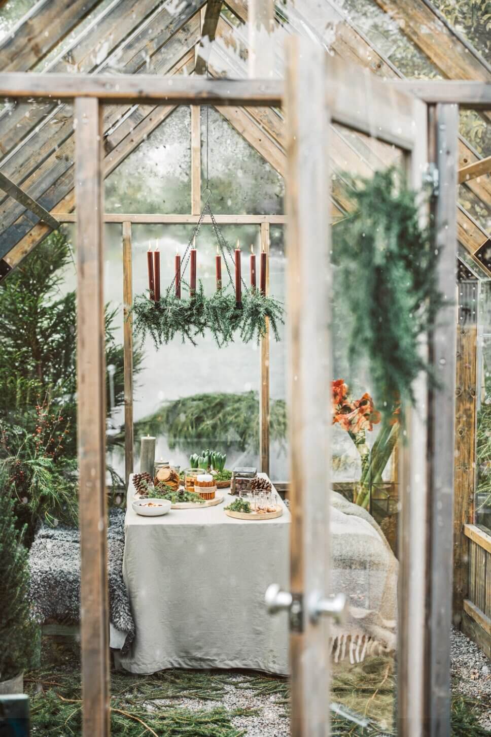 Mit skandinavischer Weihnachtsdeko geschmücktes Gewächshaus