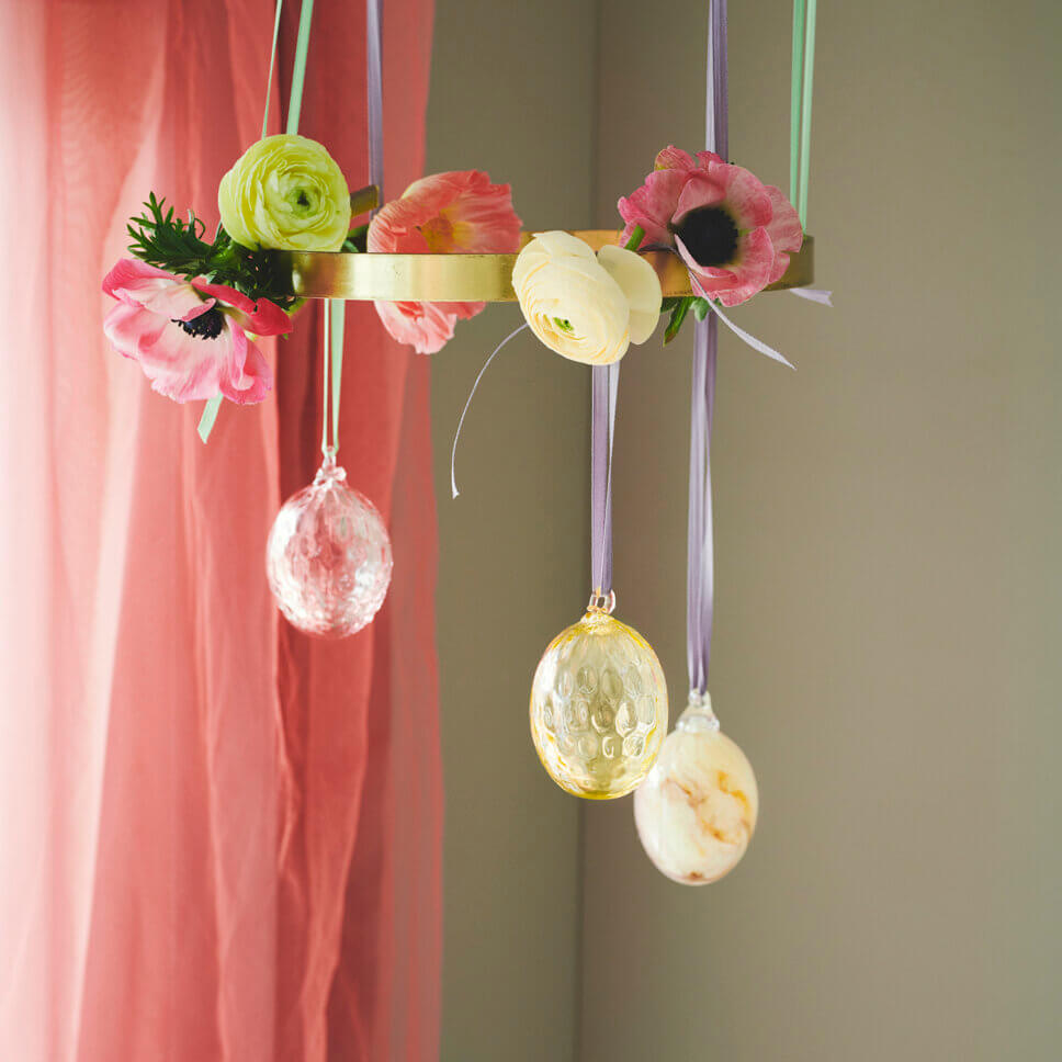 Glaseier hängen von Blumen verzierten Messingreifen herab