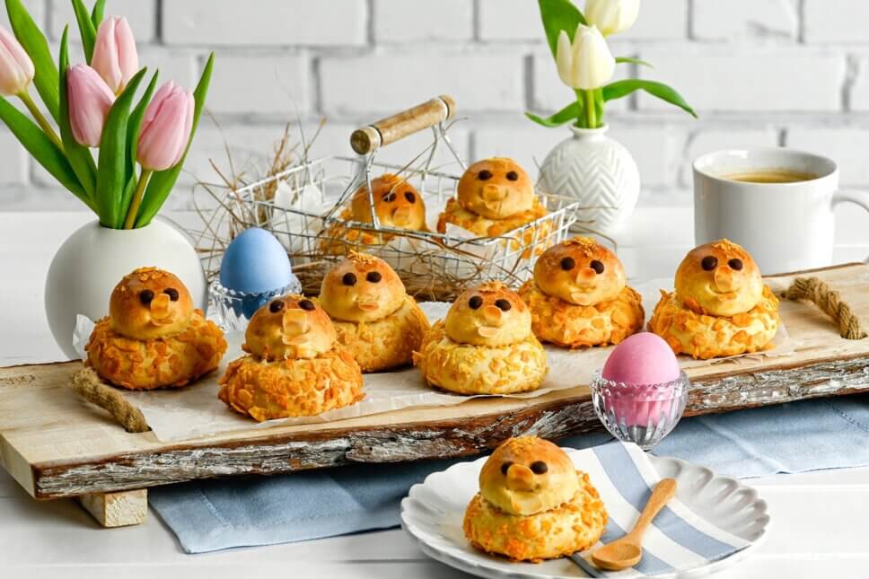 Gebäck in Kükenform auf mit blumen dekoriertem Tisch
