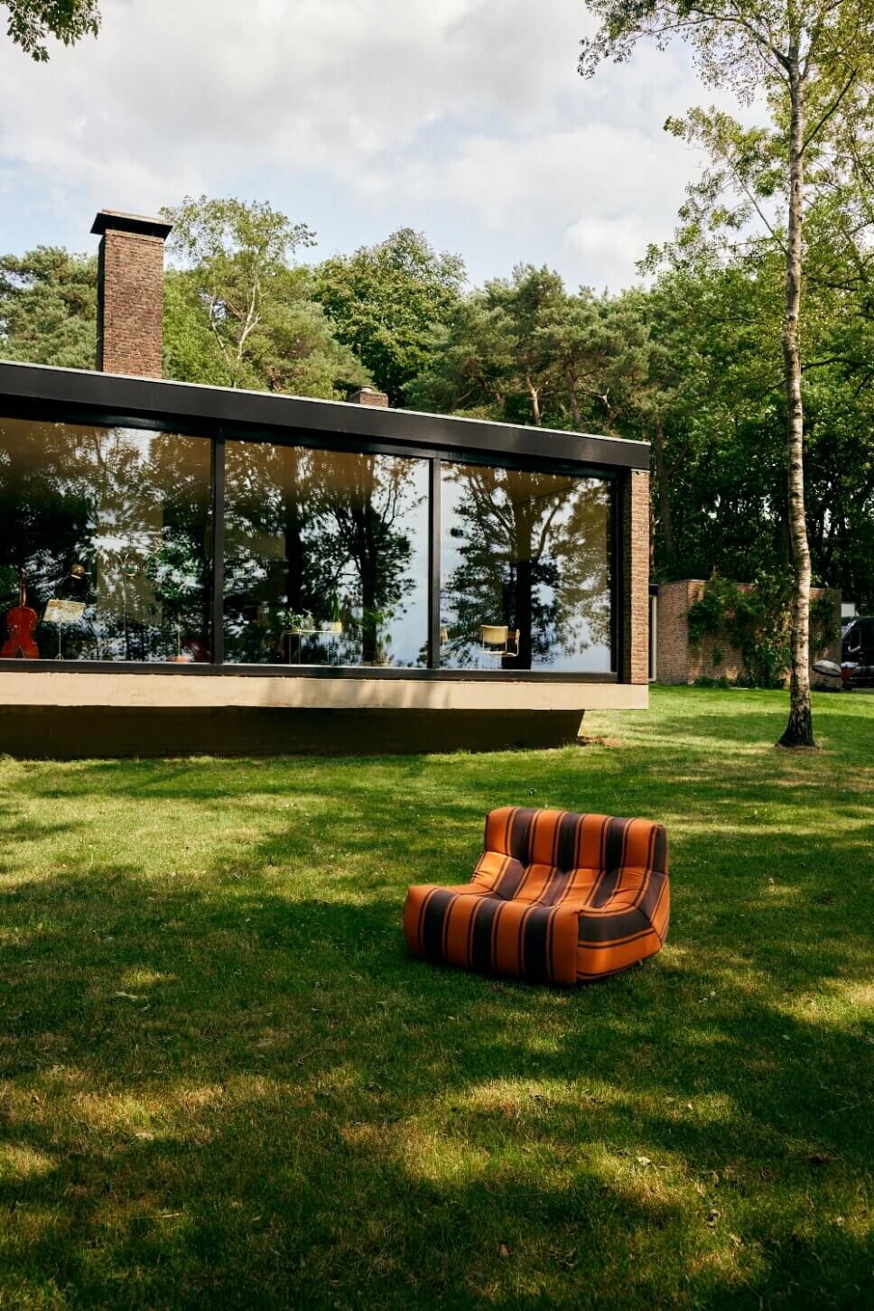 Im Stil der 70er Jahre mit modernen Retromöbeln ausgestattete Terrasse an einem Bungalow