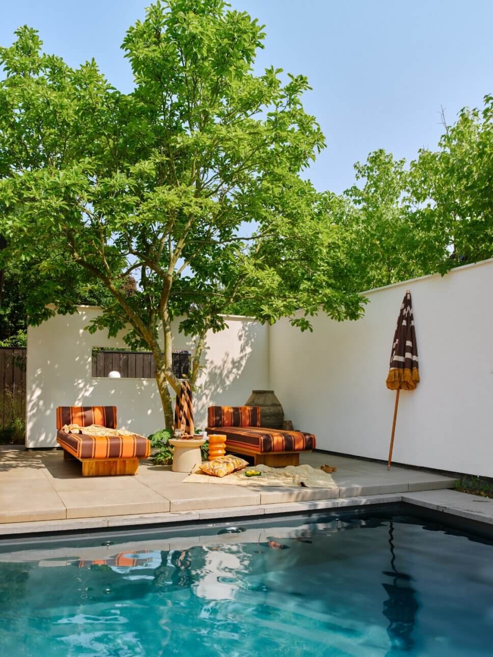 Im Stil der 70er Jahre mit modernen Retromöbeln ausgestattete Terrasse an einem Bungalow