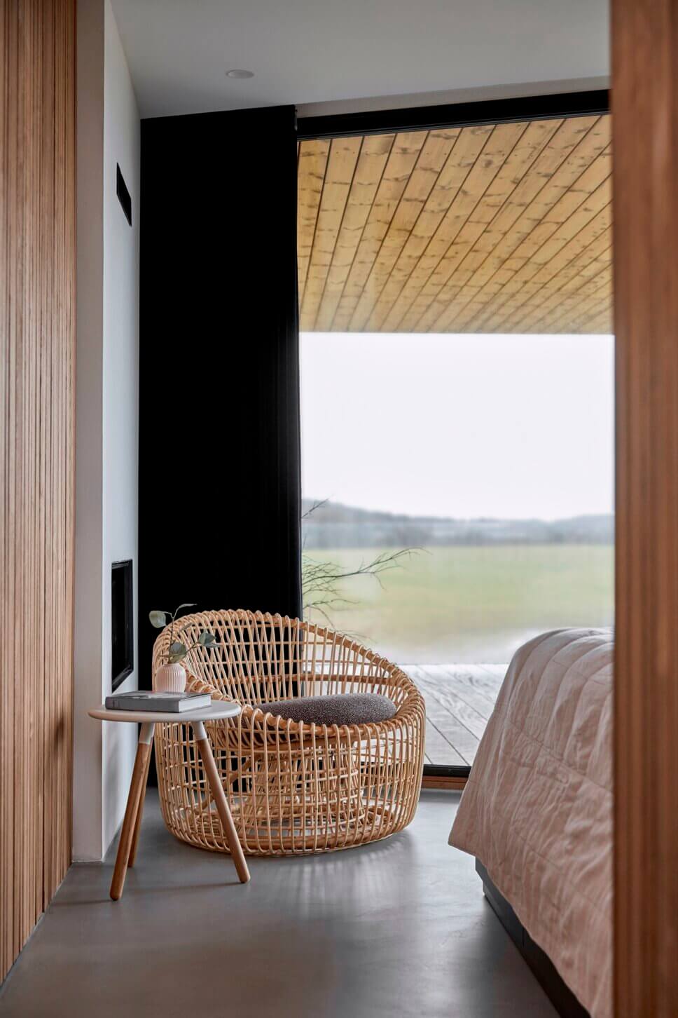 Moderner Rattansessel im Schlafzimmer vor Fenster