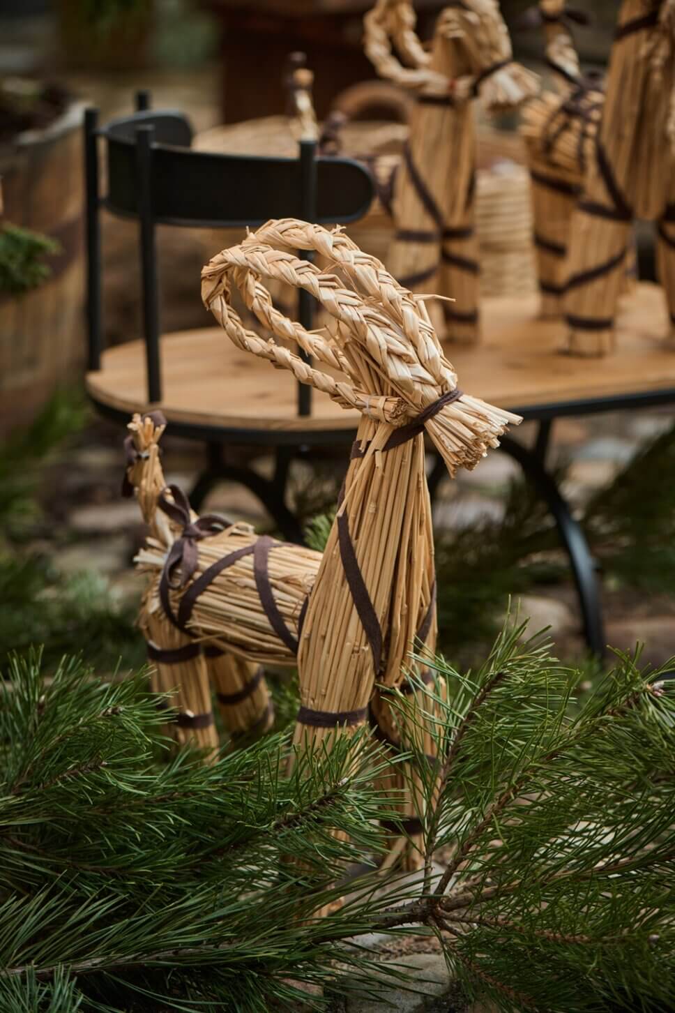 Julböcke aus Stroh stehen auf Kopfsteinpflaster im Hof