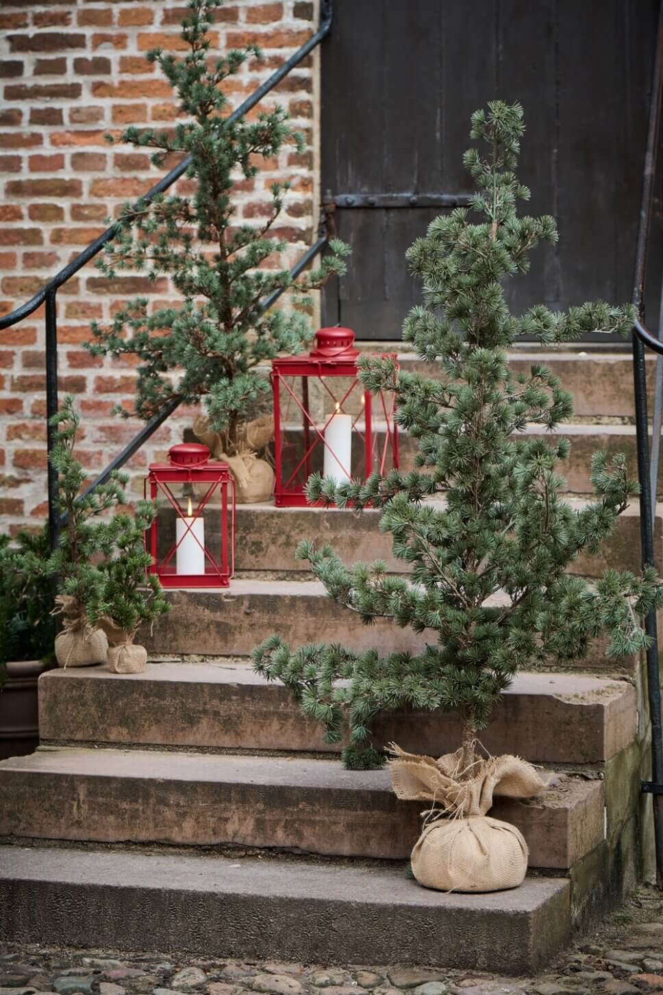Festlich mit Latenen und Tannen geschmückte Treppe im Hof
