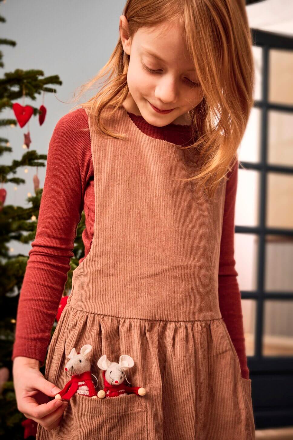 Mädchen spielt mit zwei Stoffmäusen in der Rocktasche