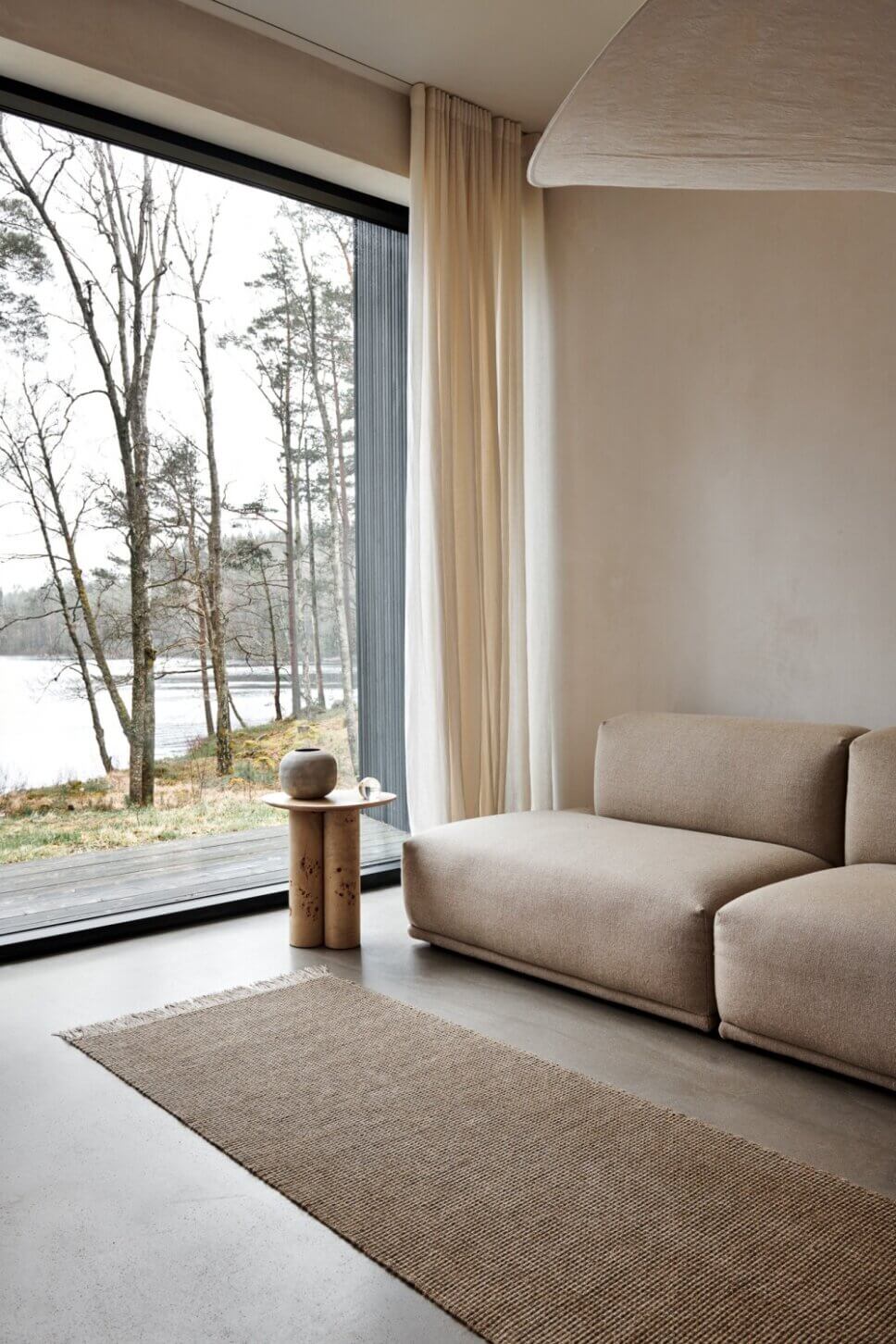 Brauner Teppich vor Sofa im modern eingerichteten Wohnzimmer