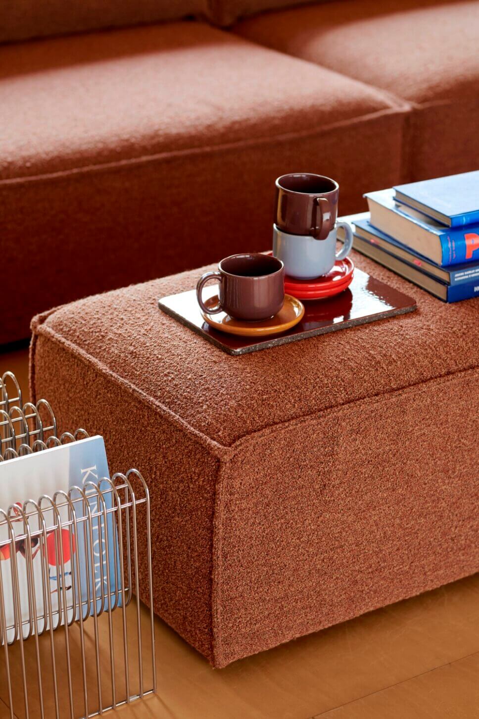 Kaffeetassen auf braunem Pouf im modern eingerichteten Wohnzimmer
