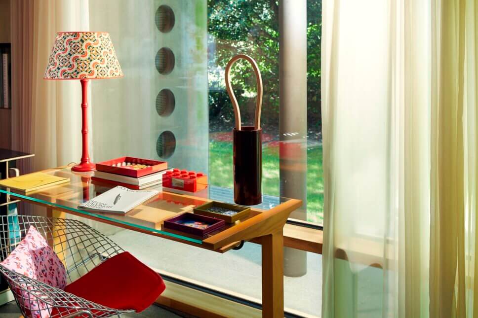 Behaglich mit farbenfrohen Tabletts, Textilien und Designklassikern modern eingerichtetes Home-Office in italienischem Bungalow