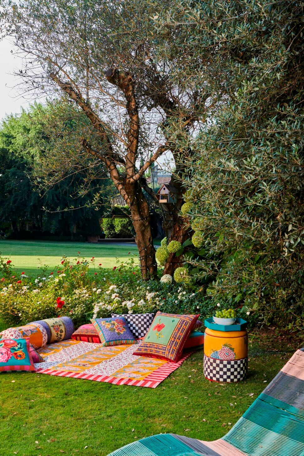 Behaglich mit farbenfrohen Stoffen und Designklassikern ausgestatteter Garten an italienischem Bungalow