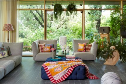 Behaglich mit farbenfrohen Stoffen und Designklassikern modern eingerichtetes Wohnzimmer in italienischem Bungalow