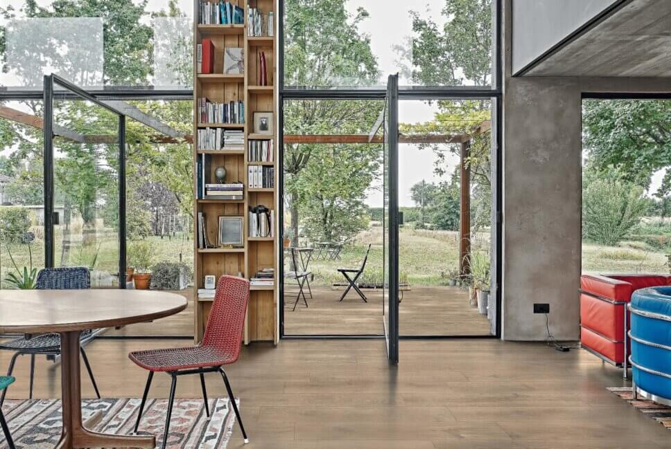 Modern eingerichteter Wohnraum mit Zugang zur Terrasse mit Fliesenboden in Optik von Eichenparkett