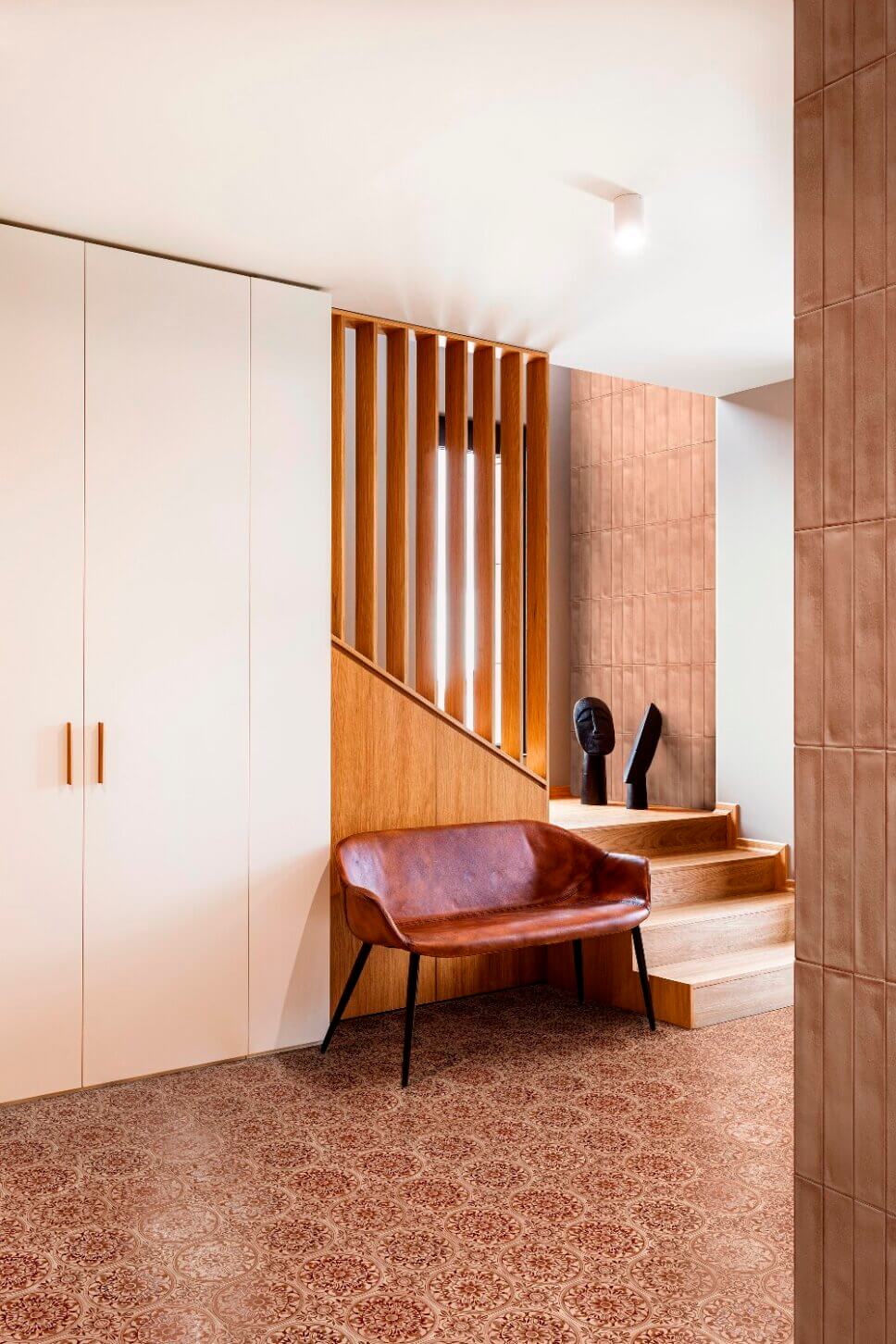 Modern eingerichteter Flur mit gemustertem Fliesenboden