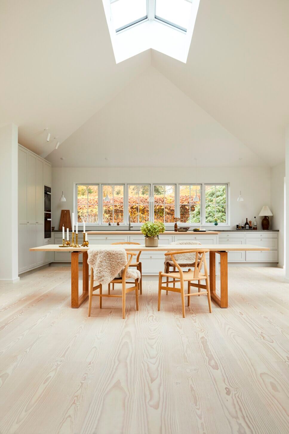 Modern eingerichtete offene Küche mit Esstisch auf Douglasien-Parkett