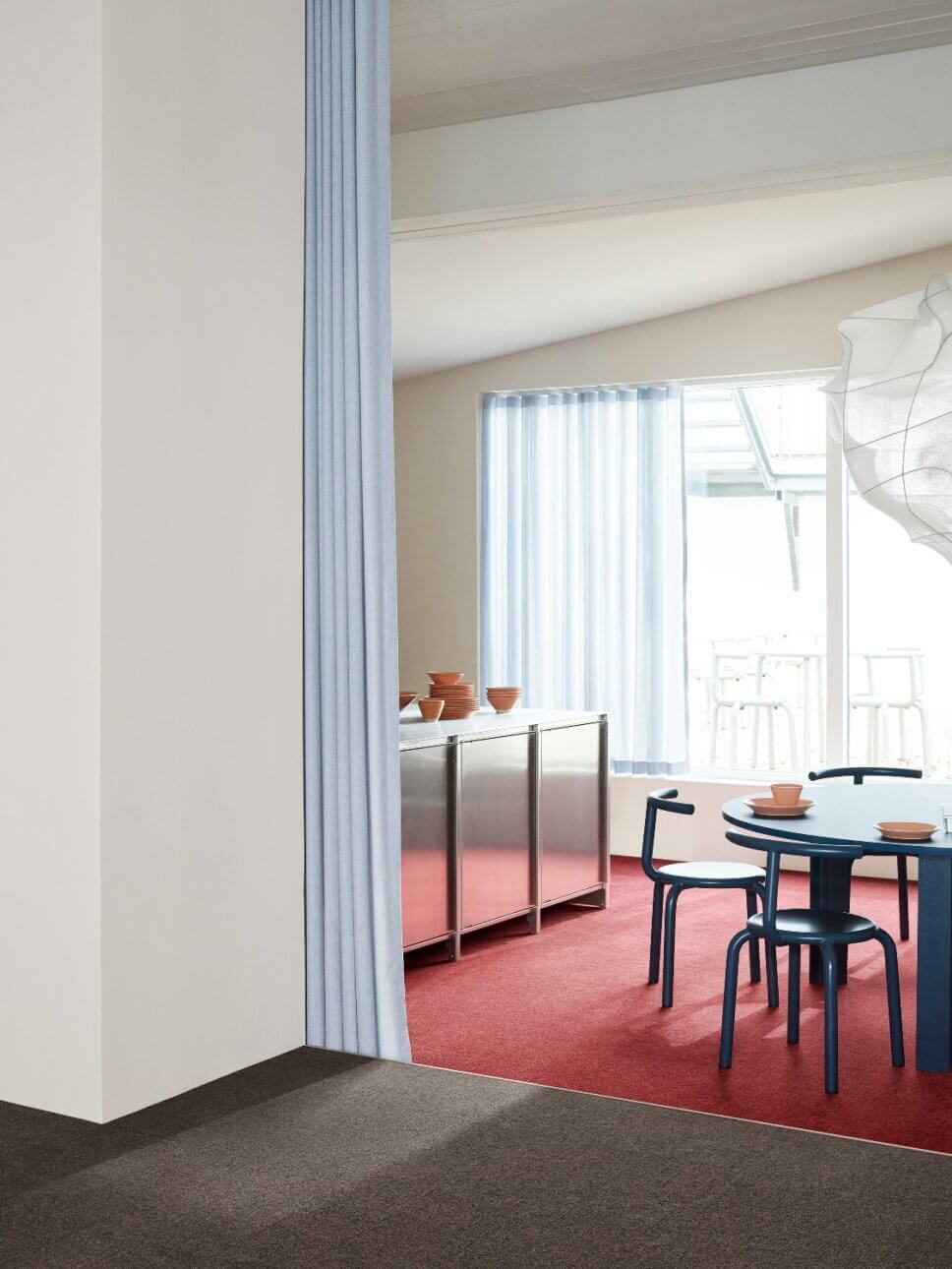 Modern eingerichtetes Esszimmer mit rotem Teppichboden