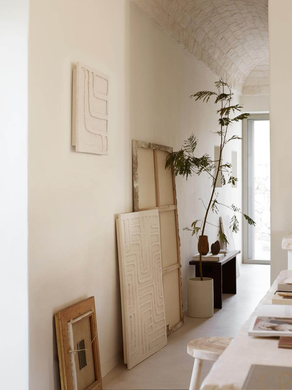 Flur mit an der Wand angelehnten Kunstwerken in mediterranem Haus mit steinerner Gewölbedecke