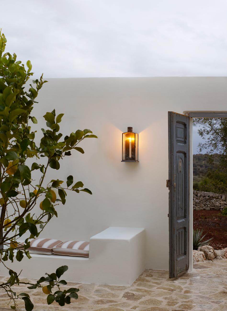 Steinbank und Kerzenleuchter an mediterranem weißen Haus