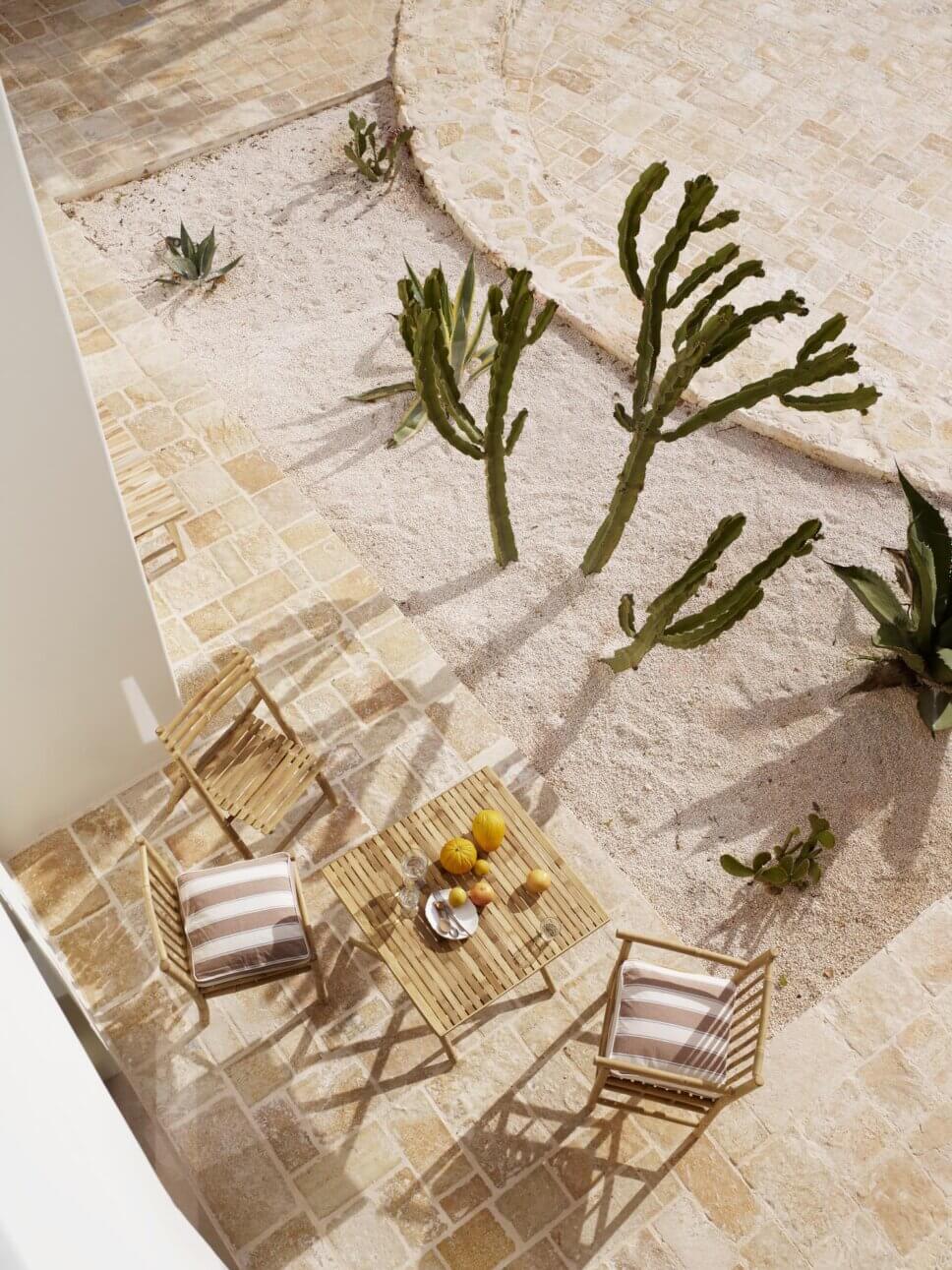 Holz-Gartenmöbel auf Terrasse aus Natursteinen