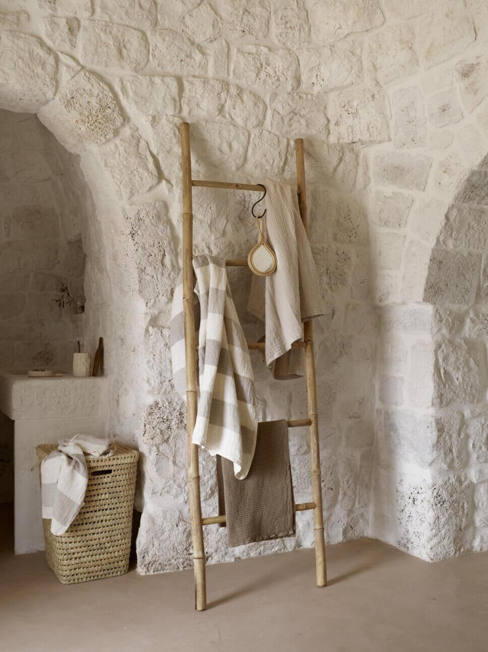 Badezimmer mit Handtuchleiter aus Bambus und Waschbecken in mediterranem Haus mit steinerner Gewölbedecke