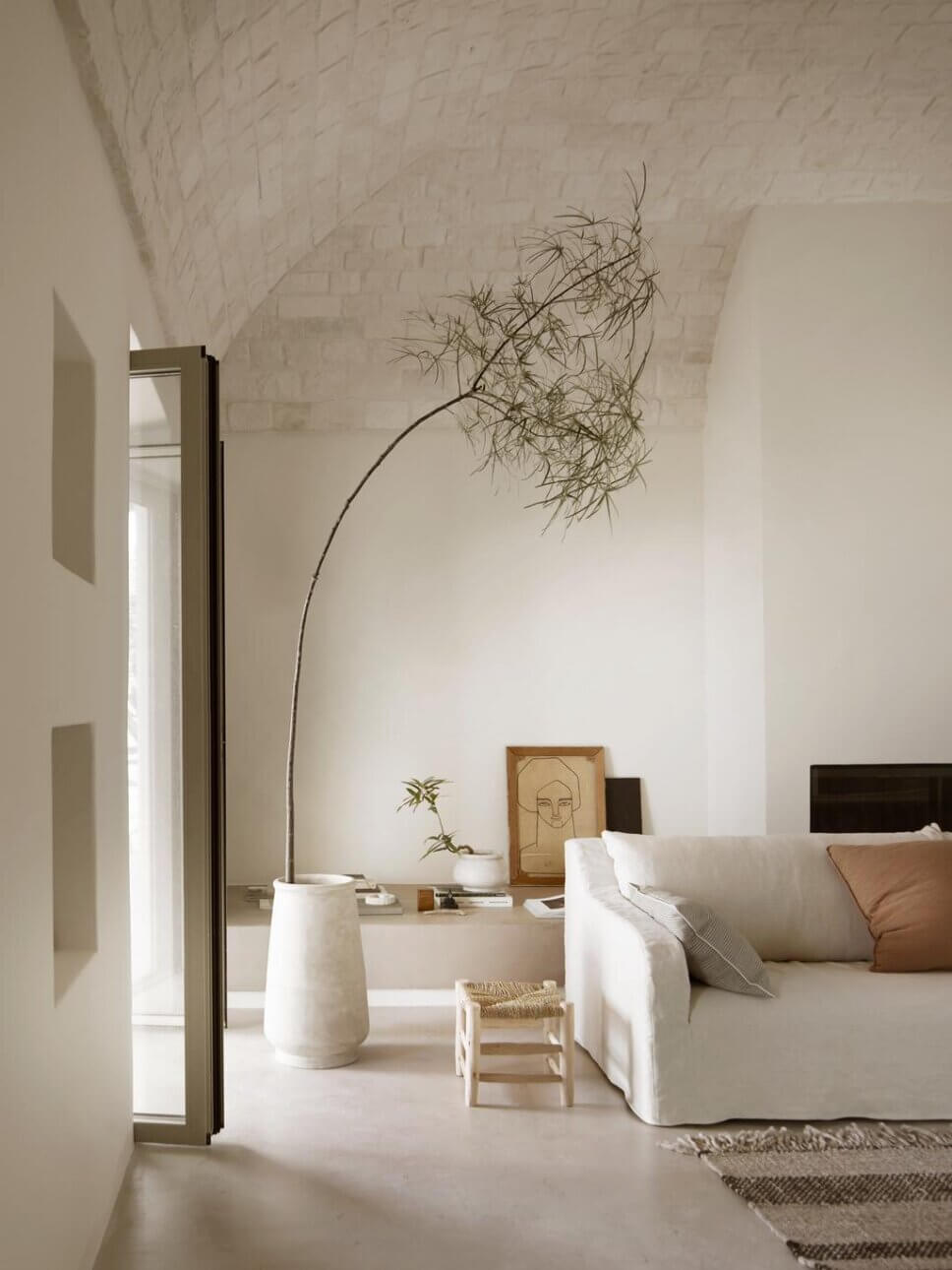 Modernes Wohnzimmer mit weißem Sofa in mediterranem Haus mit steinerner Gewölbedecke