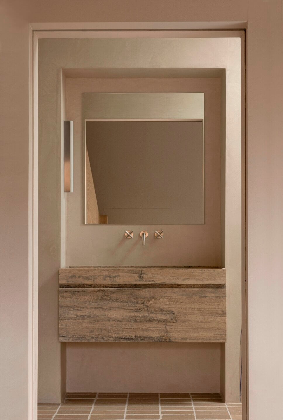 Minimalistisch eingerichtetes Badezimmer mit Waschtisch aus Travertin in Architektenhaus