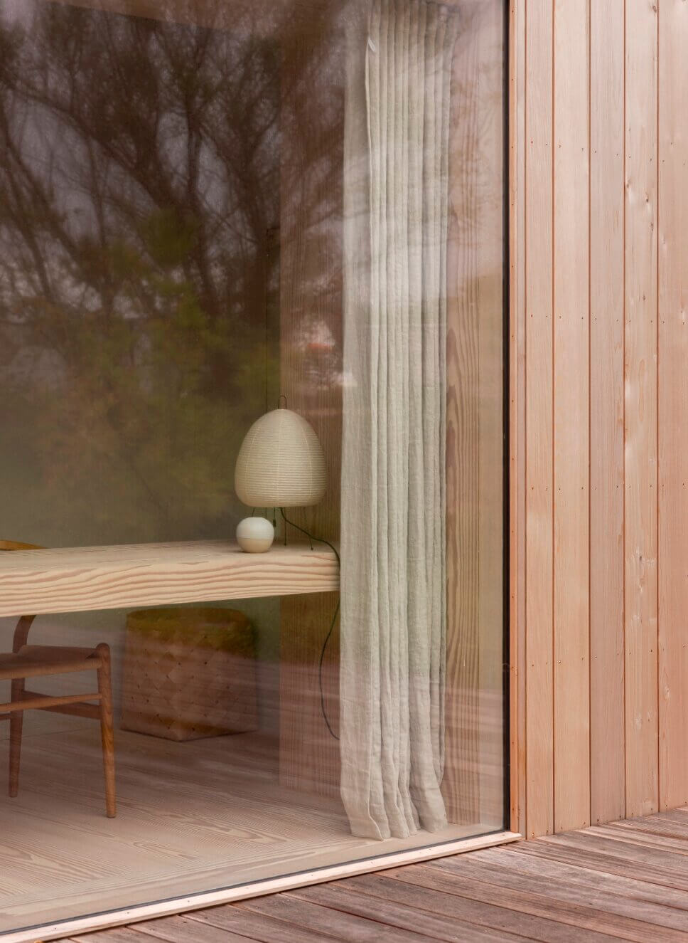 Blick durch Fenster in einen minimalistisch eingerichteten Raum in Architektenhaus