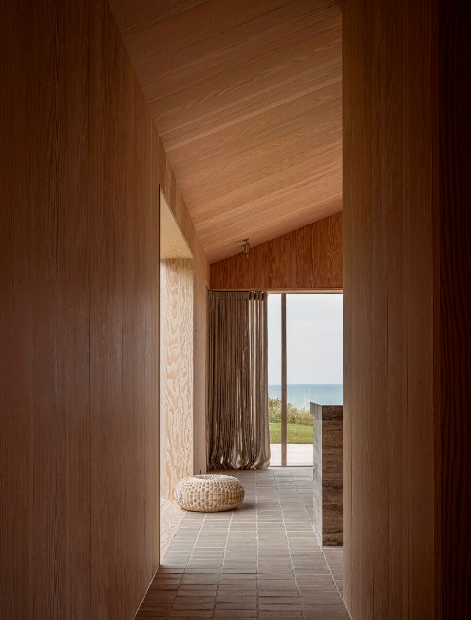 Blickachse im Flur in einem minimalistisch eingerichteten, mit Holz vertäfelten Architektenhaus