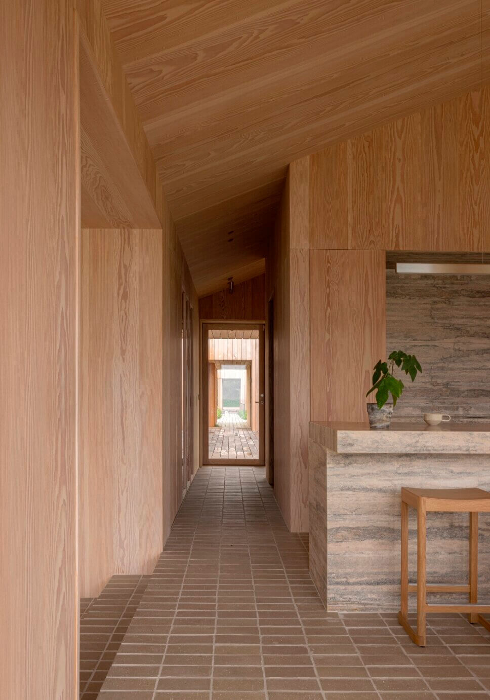 Blickachse im Flur in einem minimalistisch eingerichteten, mit Holz vertäfelten Architektenhaus