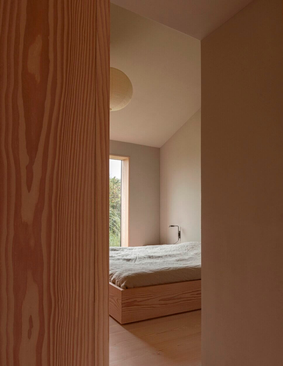 Minimalistisch eingerichtetes, mit Holz vertäfeltes Schlafzimmer in Architektenhaus