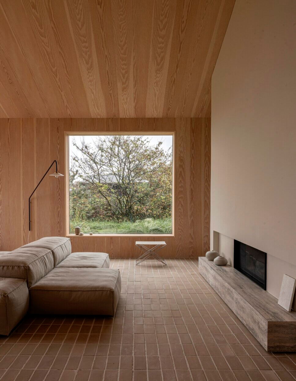Minimalistisch eingerichtetes, mit Holz vertäfeltes Wohnzimmer in Architektenhaus mit Panoramafenster und Kamin