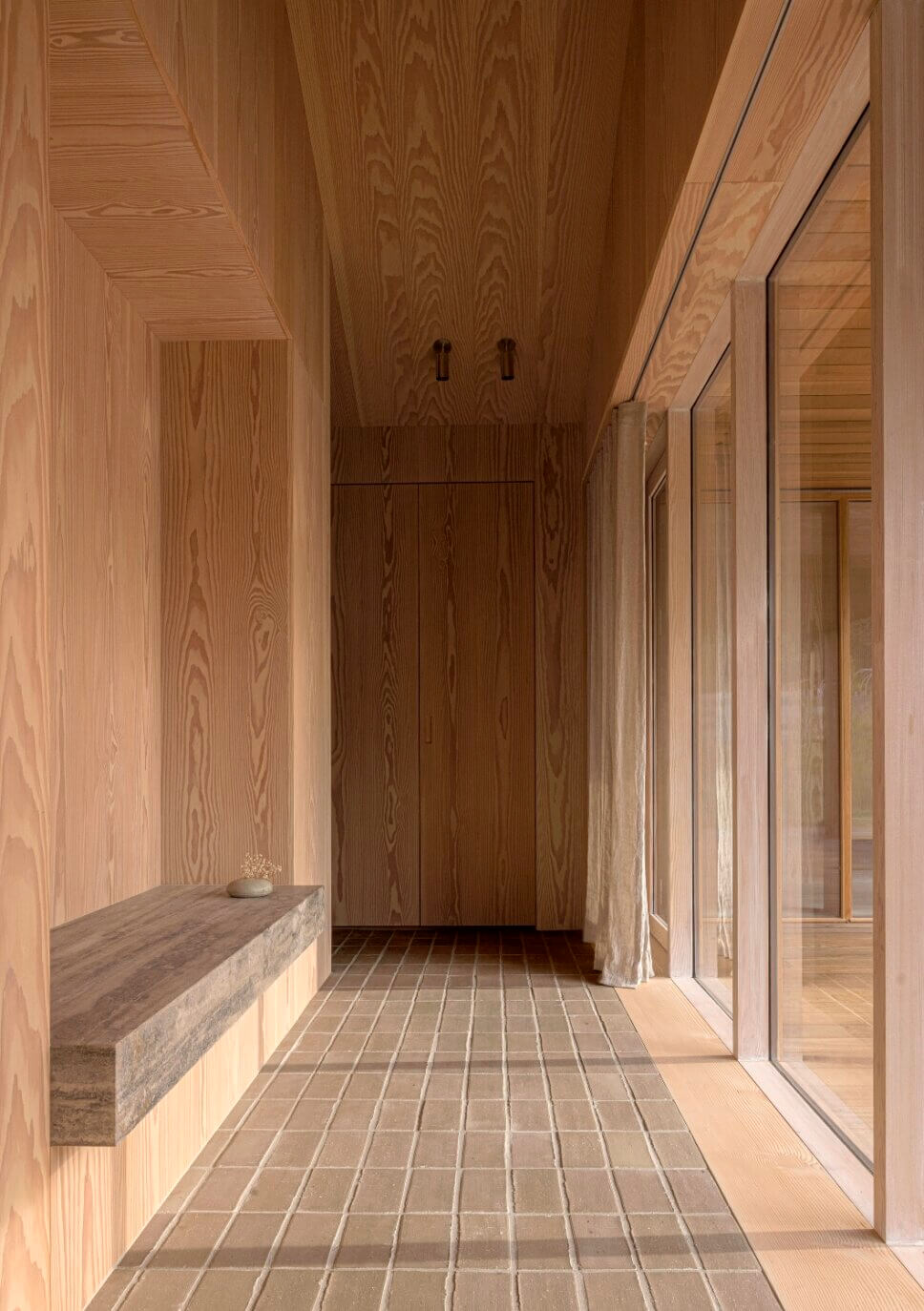 Blickachse im Flur in einem minimalistisch eingerichteten, mit Holz vertäfelten Architektenhaus