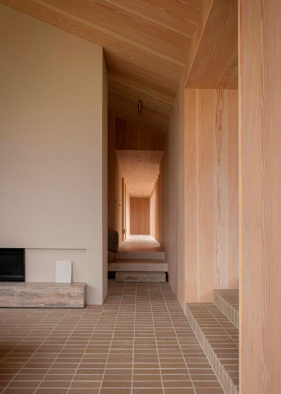 Blickachse im Flur in einem minimalistisch eingerichteten, mit Holz vertäfelten Architektenhaus