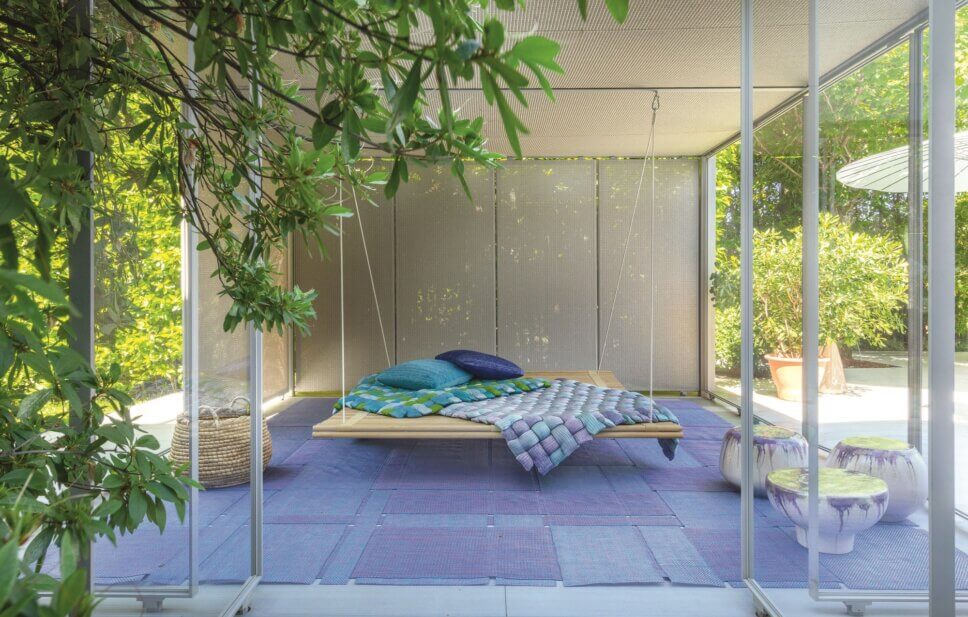 Moderne Hängematte hängt in überdachter Terrasse